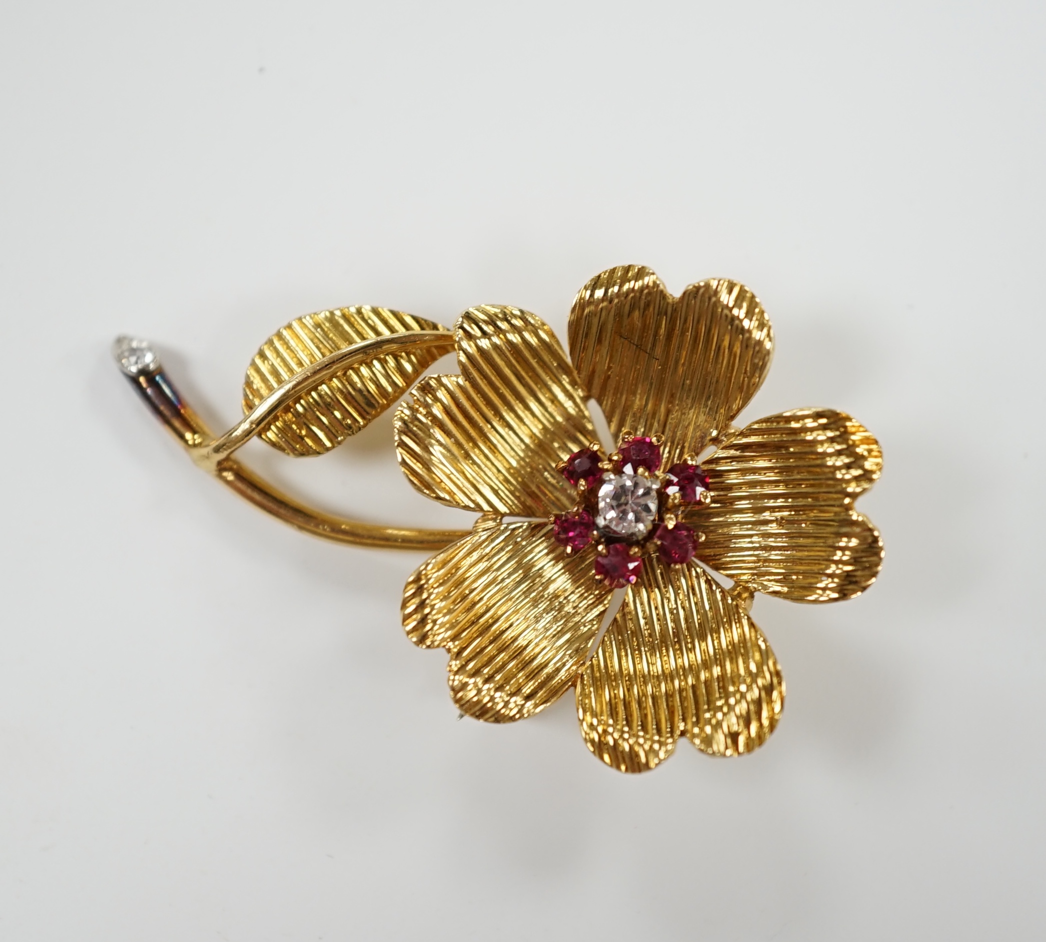 An 18ct, ruby and diamond cluster set flower brooch, 35mm, gross weight 6.3 grams.